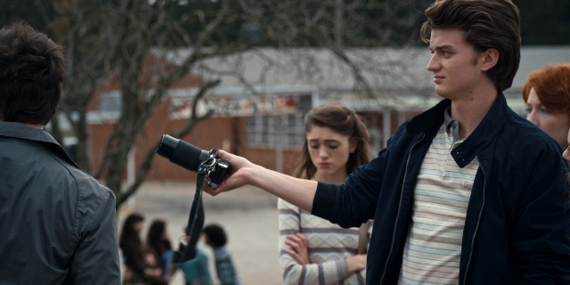 Wide shot frame from Stranger Things — standing, hand, shirt
