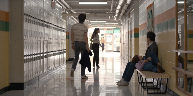 Wide shot frame from Stranger Things — sitting, walking, dialogue