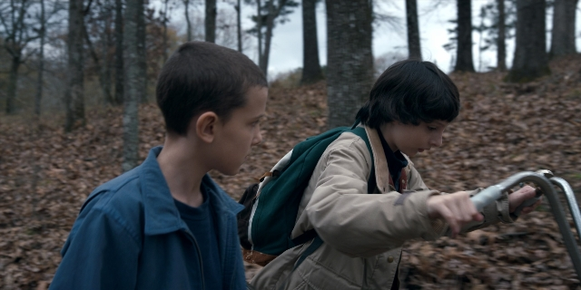 Wide shot frame from Stranger Things — standing, face, hair