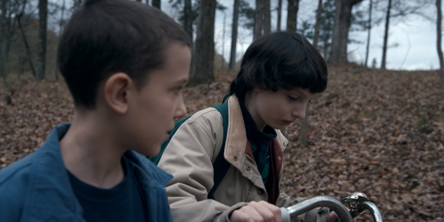 Wide shot frame from Stranger Things — sitting, shirt, face