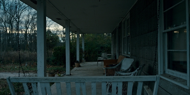 Wide shot frame from Stranger Things — house, chair, porch