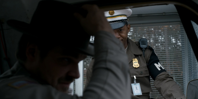 Wide shot frame from Stranger Things — sitting, dialogue, street