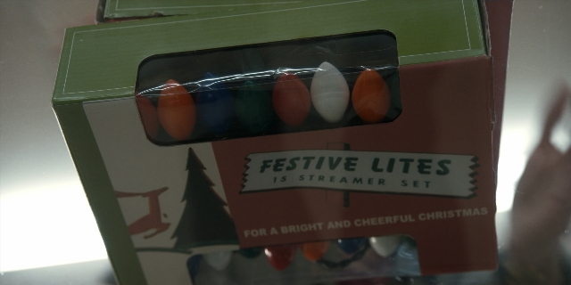 Wide shot frame from Stranger Things — hand, box, person