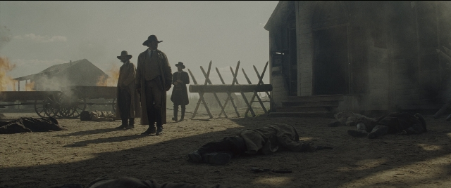 Wide shot frame from The Magnificent Seven — standing, fire, person