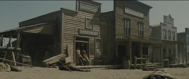 Wide shot frame from The Magnificent Seven — house, office, window