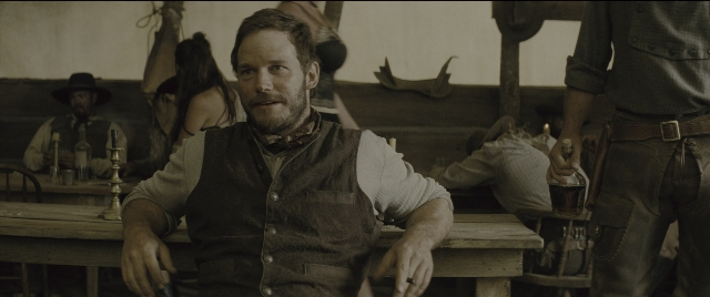 Wide shot frame from The Magnificent Seven — sitting, standing, room