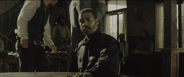Wide shot frame from The Magnificent Seven — sitting, standing, room