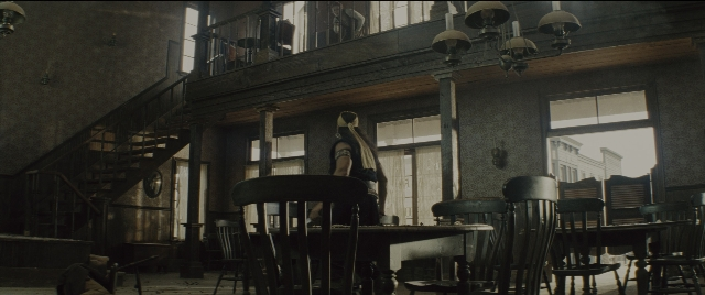 Wide shot frame from The Magnificent Seven — sitting, room, table