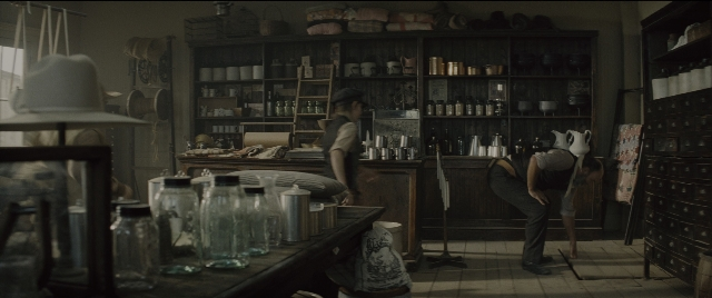 Wide shot frame from The Magnificent Seven — standing, room, table