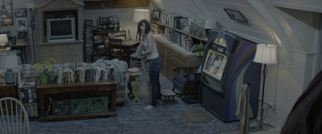 Wide shot frame from 10 Cloverfield Lane — book, standing, room
