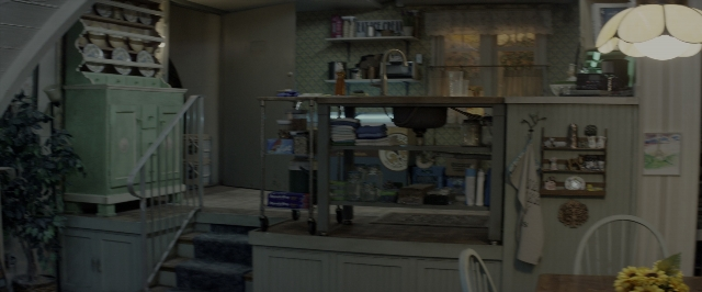 Wide shot frame from 10 Cloverfield Lane — room, table, house