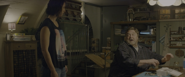Wide shot frame from 10 Cloverfield Lane — sitting, standing, table