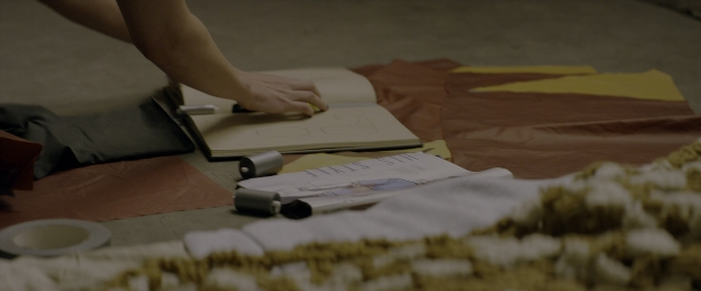 Frame from 10 Cloverfield Lane — book, table, hand