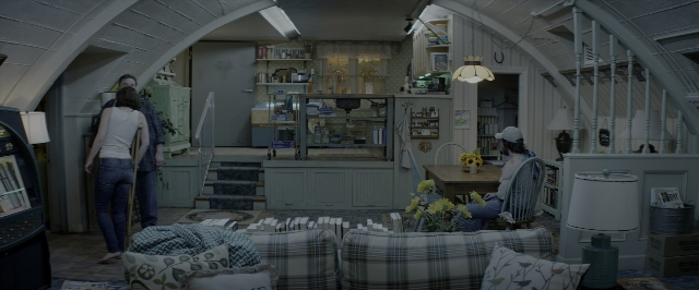 Wide shot frame from 10 Cloverfield Lane — sitting, standing, room