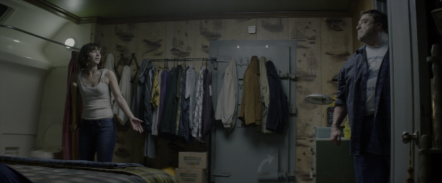 Wide shot frame from 10 Cloverfield Lane — standing, room, bed