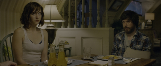 Wide shot frame from 10 Cloverfield Lane — sitting, room, table