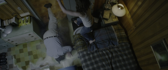 Wide shot frame from 10 Cloverfield Lane — standing, room, bed