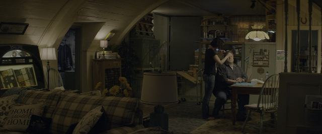 Wide shot frame from 10 Cloverfield Lane — sitting, room, table