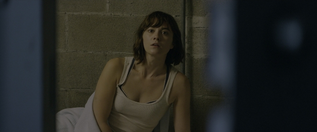 Wide shot frame from 10 Cloverfield Lane — sitting, room, bed