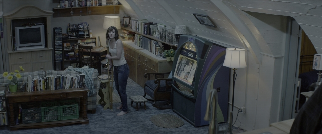 Wide shot frame from 10 Cloverfield Lane — book, standing, room