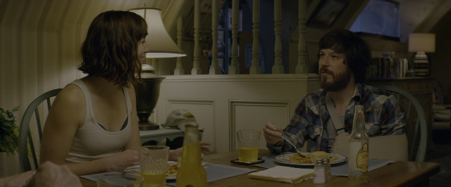 Wide shot frame from 10 Cloverfield Lane — sitting, table, dialogue