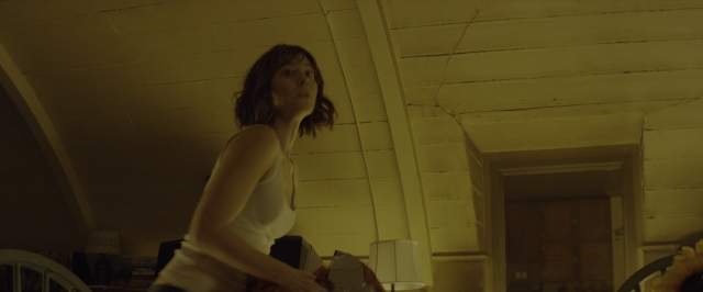 Wide shot frame from 10 Cloverfield Lane — standing, room, table