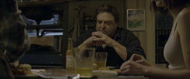 Wide shot frame from 10 Cloverfield Lane — sitting, standing, table