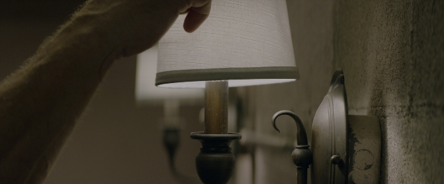 Frame from 10 Cloverfield Lane — room, table, hand