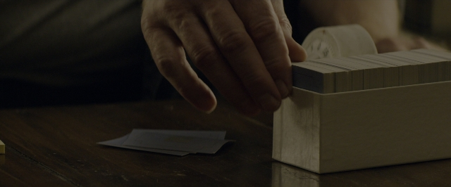Frame from 10 Cloverfield Lane — table, hand, box