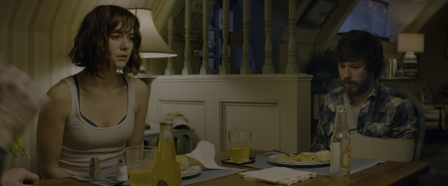 Wide shot frame from 10 Cloverfield Lane — sitting, plate, room
