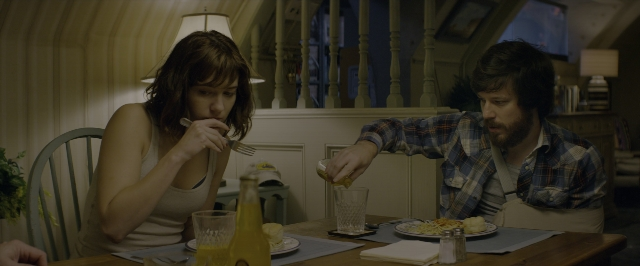 Wide shot frame from 10 Cloverfield Lane — sitting, plate, room