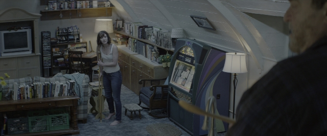 Wide shot frame from 10 Cloverfield Lane — book, standing, room