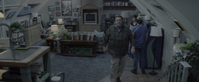 Wide shot frame from 10 Cloverfield Lane — walking, room, table