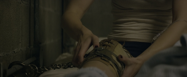 Wide shot frame from 10 Cloverfield Lane — sitting, room, bed