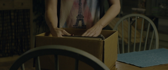 Wide shot frame from 10 Cloverfield Lane — room, table, shirt
