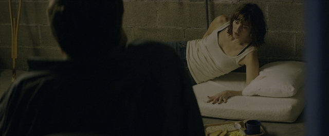Wide shot frame from 10 Cloverfield Lane — sitting, plate, room