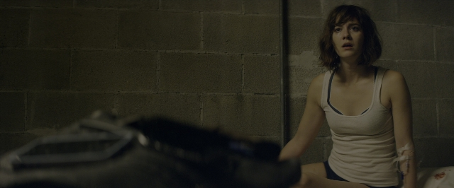 Wide shot frame from 10 Cloverfield Lane — sitting, room, bed