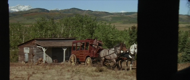 Wide shot frame from Unforgiven — hat, coat, house