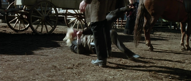 Wide shot frame from Unforgiven — standing, coat, horse