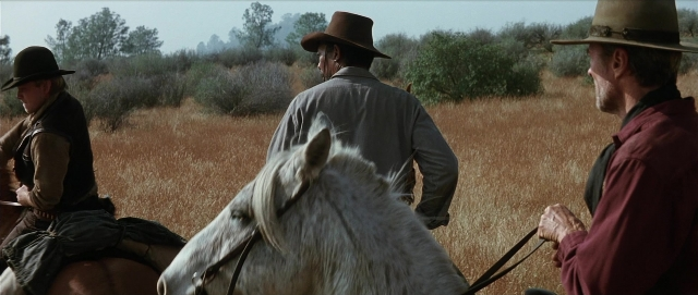 Frame from Unforgiven — sitting, standing, dialogue