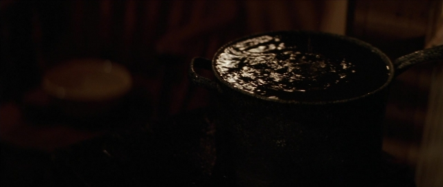 Wide shot frame from Unforgiven — room, table, drink