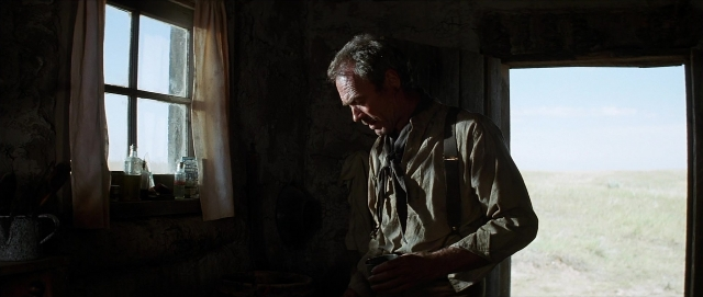 Wide shot frame from Unforgiven — standing, room, table