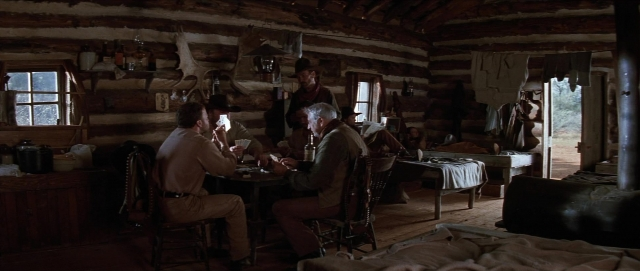 Wide shot frame from Unforgiven — sitting, standing, room