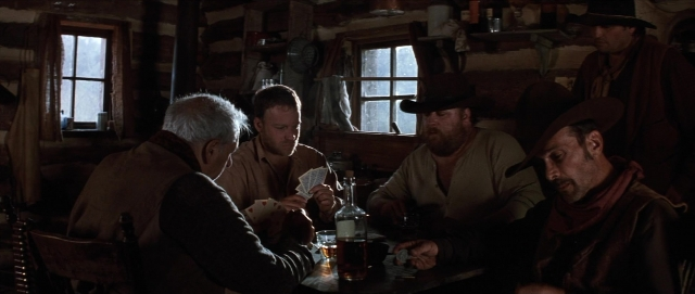 Wide shot frame from Unforgiven — sitting, room, table