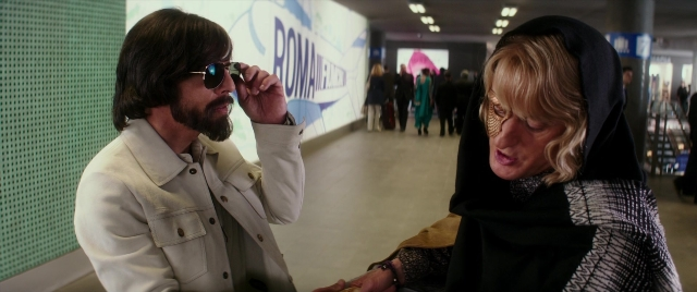 Wide shot frame from Zoolander 2 — walking, coat, beard