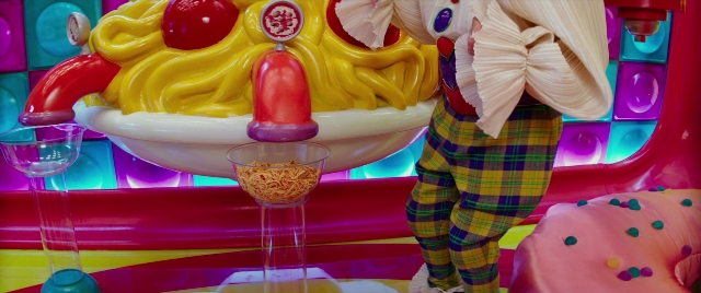 Wide shot frame from Zoolander 2 — glass, dessert, person