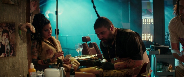 Wide shot frame from Zoolander 2 — sitting, room, table