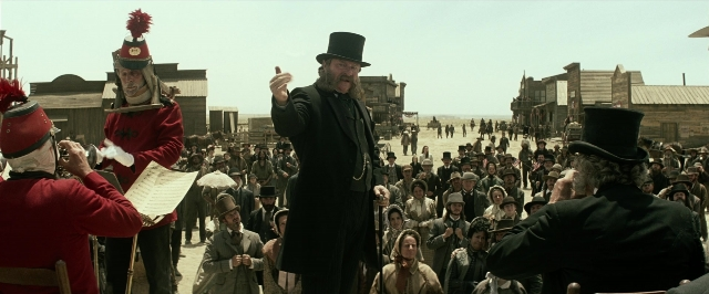Wide shot frame from The Lone Ranger — standing, hat, coat