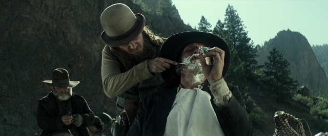 Wide shot frame from The Lone Ranger — standing, hat, hand