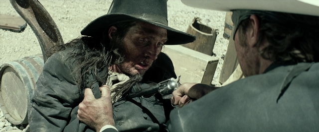 Wide shot frame from The Lone Ranger — sitting, dialogue, hat